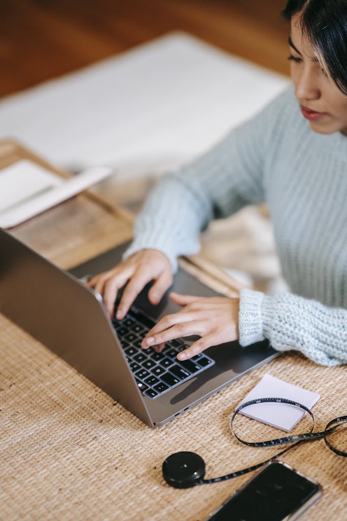 Woman working while typing on laptop